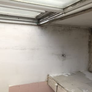 קיר עם סימני רטיבות ותקרה עם חלון זכוכית