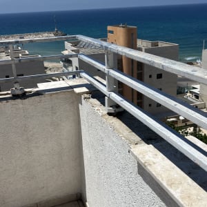 מרפסת עם נוף לים ומעקה מתכת
