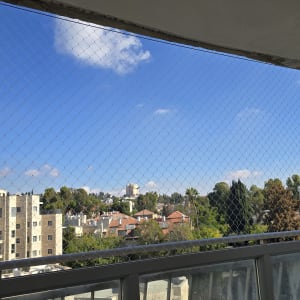 התקנת רשת שקופה נגד יונים במרפסת דירה