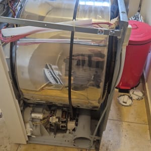 מכונת כביסה פתוחה עם תוף חשוף וחוטי חשמל