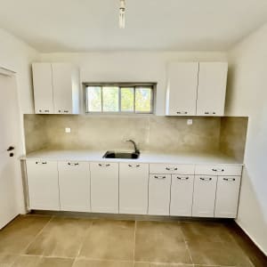 מטבח משופץ עם ארונות לבנים וכיור חדש