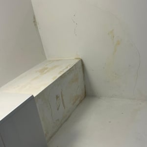 קיר עם סימני רטיבות ותיקונים בצבע