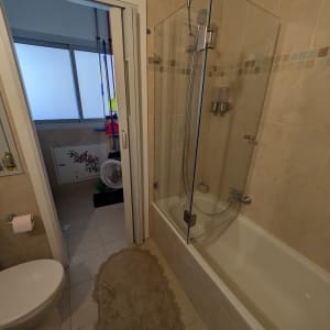 חדר אמבטיה עם אמבטיה, דלת זכוכית ומקלחת