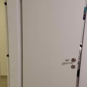 דלת לבנה עם ידית מתכת כסופה