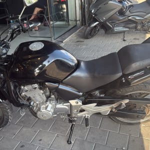 אופנוע שחור חונה על מדרכה ליד חנות