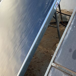 קולט שמש עם צינור ומיכל מים על גג