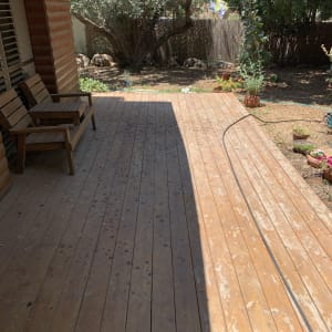 דק עץ עם כיסאות ליד גינה