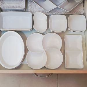 צלחות לבנות מסודרות במגירה במטבח