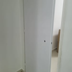 דלת פתוחה עם קיר לבן ורצפה בהירה