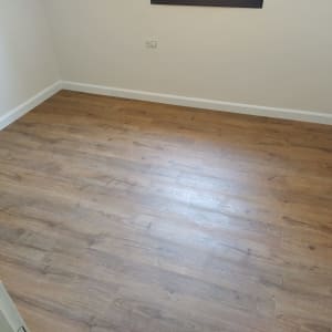 רצפת פרקט עץ בחדר ריק עם קירות לבנים