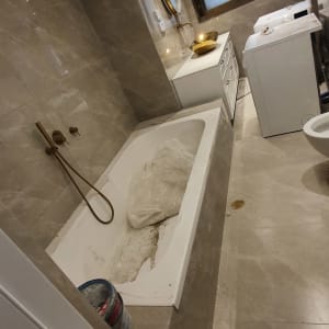 אמבטיה עם שקיות פלסטיק ודלי צבע על הרצפה