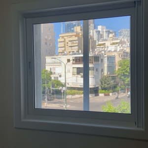 חלון אלומיניום עם נוף עירוני ברקע