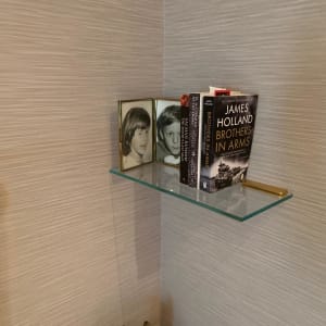 מדף זכוכית עם ספרים ותמונות במסגרת זכוכית