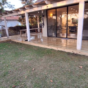 דק עץ עם כיסאות גינה ליד בית