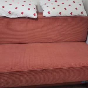 ספה עם כריות לבבות על רקע קיר לבן