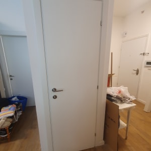 דלת לבנה עם ידית מתכת בחדר פנימי