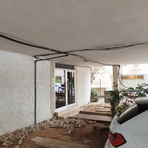 התקנת צנרת מים שחורה לאורך תקרה וקיר בבניין מגורים