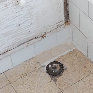 רצפת אריחים עם פתח ניקוז חלוד