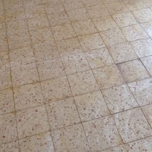 רצפת אריחים ישנה עם סימני לכלוך ושחיקה
