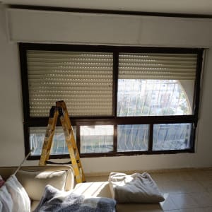 סולם ליד חלון עם תריסים סגורים