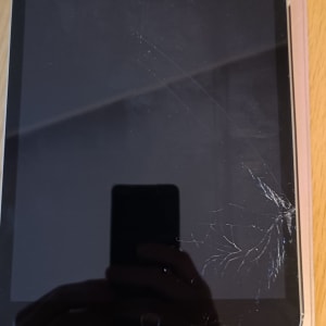 מסך אייפד סדוק על שולחן עץ