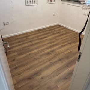 רצפת פרקט בחדר עם פוסטרים על הקיר