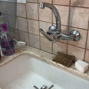 ברז כיור עם כלים וספוג ניקוי