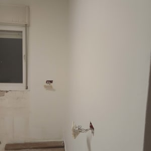קיר צבוע עם חלון ושקעי חשמל