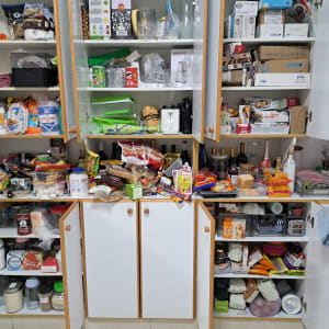 ארונות מטבח פתוחים עם מוצרי מזון וכלים שונים