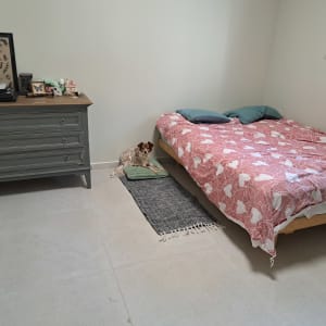 חדר שינה מסודר עם מיטה זוגית, שידת מגירות ועיצוב נקי
