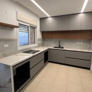 מטבח חדש עם ארונות אפורים ומשטחי שיש