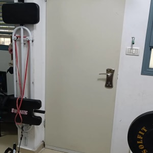 דלת לבנה עם ידית מתכת בחדר כושר ביתי