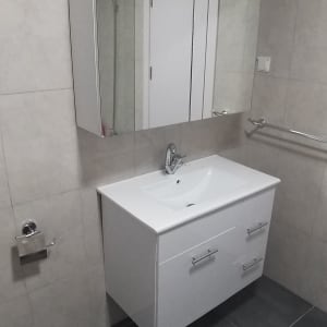 כיור לבן עם ברז בחדר אמבטיה נקי