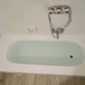 אמבטיה לבנה עם מים, ברז ומקלחת יד