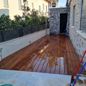 דק עץ רטוב עם צינור ומטאטא