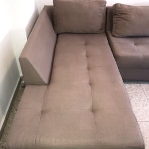 ספה חומה עם כריות על רצפת אריחים