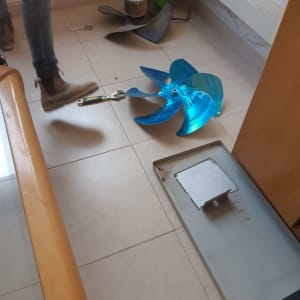 מאוורר כחול וכלים על רצפה ליד מזגן