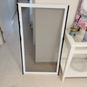 מסגרת אלומיניום לבנה עם זכוכית מונחת על הרצפה