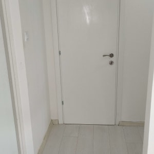 דלת לבנה עם ידית מתכת, כלים על הרצפה