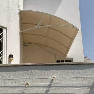 סוכך מתכת לבן מעל מרפסת