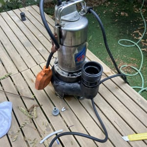 משאבה עם צינורות וכלי עבודה על שולחן עץ