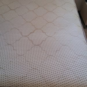 מזרן עם כתמים על כיסוי בד לבן