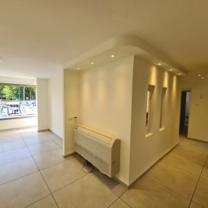 קירות לבנים עם תאורה שקועה ותנור חימום על הקיר