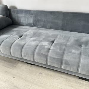 ספה אפורה עם סימני ניקוי על הבד