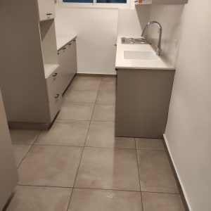 מטבח נקי עם רצפה מבריקה וכיור מסודר