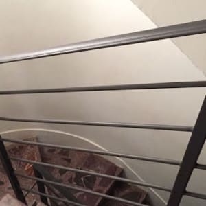 מעקה מתכת אפור במדרגות פנימיות