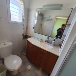 חדר אמבטיה עם ארון כיור, מראה, ושירותים