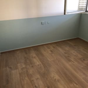 חדר צבוע בשני גוונים עם רצפת עץ