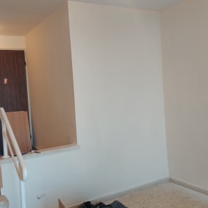 קיר צבוע בלבן עם מנורה תלויה