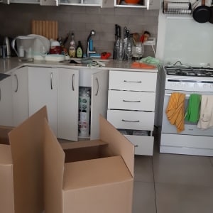 מטבח עם קופסאות קרטון פתוחות על הרצפה